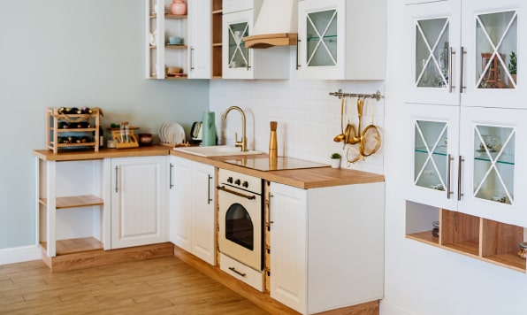 A small white kitchen with glass-paneled cabinetry.